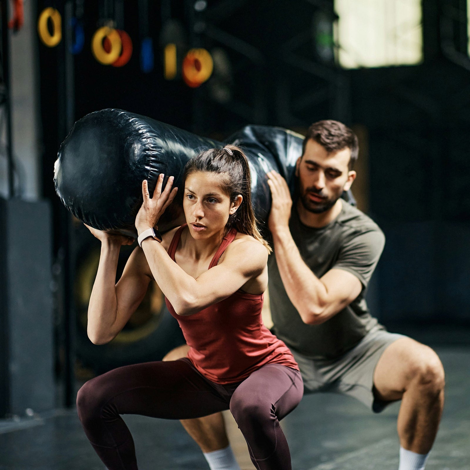 Woman & man carrying a heavy bag  