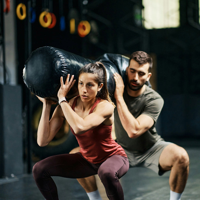 Woman & man carrying a heavy bag  